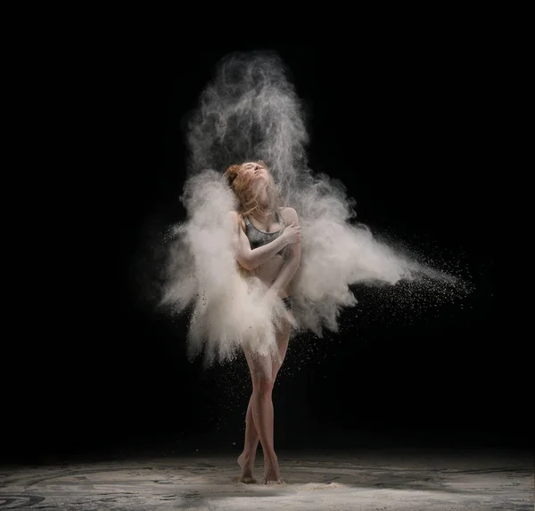 Босонога жінка танцює в хмарі піску — стокове фото