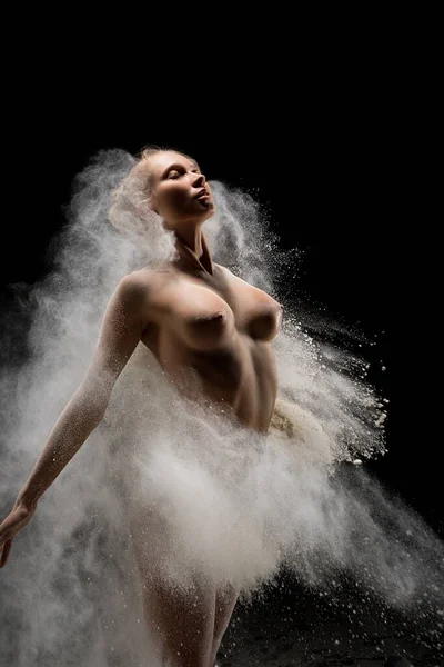 Üstsüz bir kadın toz bulutuna sığar — Stok fotoğraf