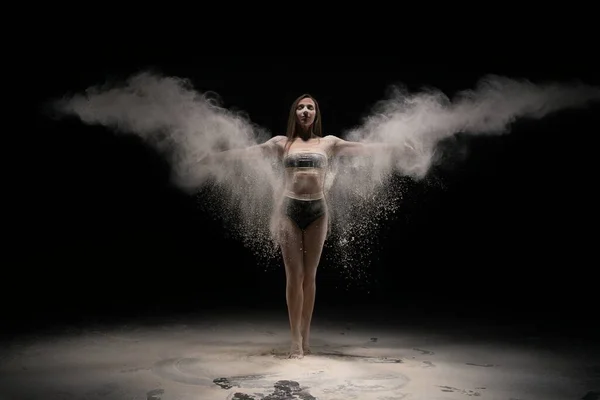 Brunett kvinna i sportkläder kasta sand i luften — Stockfoto
