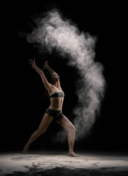 Slim female dancer throwing dust in air — Stock Photo, Image