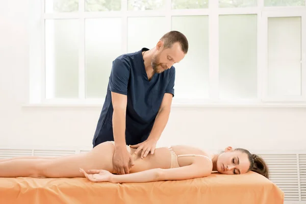 Bearded osteopath massaging back of woman — Stock Photo, Image