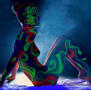 Ultraviyole ışığın altında parıldayan vücut sanatı olan kız.