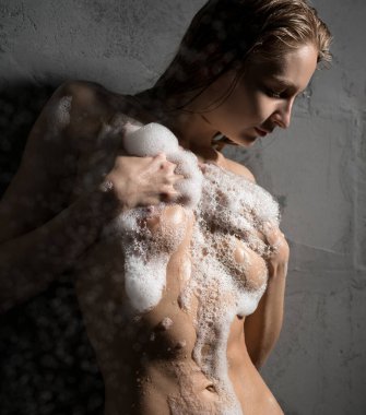 Genç sarışın köpüksüz poz veriyor.