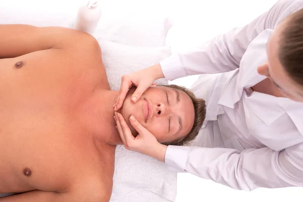 Woman doing massage on face of male client — Stock Photo, Image