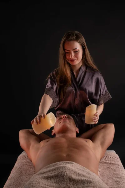 Hombre disfrutando de masaje con velas en el salón de spa — Foto de Stock