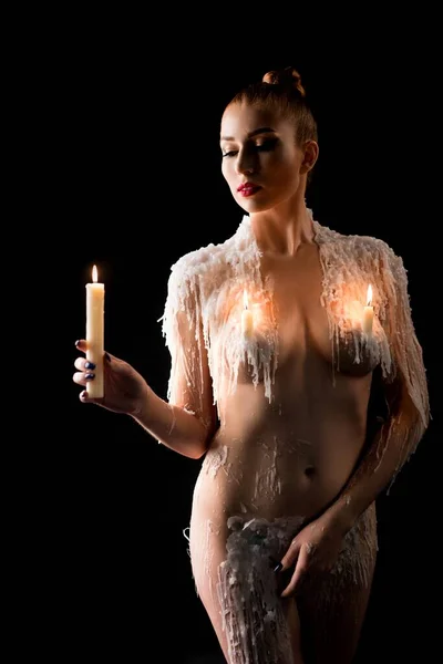 Oben-ohne-Frau sieht Kerzenfeuer in Wachs — Stockfoto