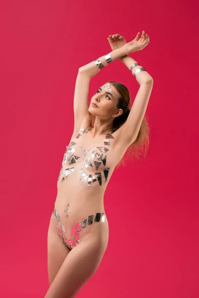 Femme mince avec des autocollants métalliques sur le corps sur fond rose — Photo