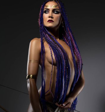 Oklu ve yaylı üstsüz seksi atlı kadın.