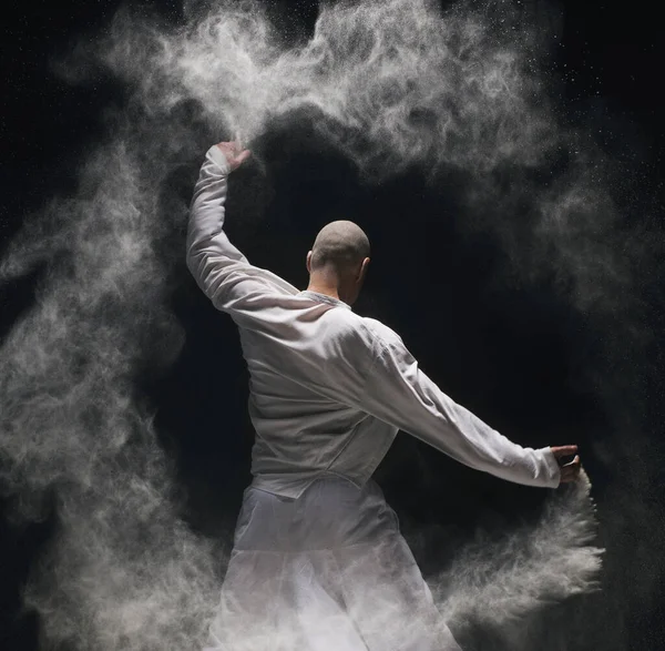 Мужчина занимается йогой в белом облаке пыли заднего вида — стоковое фото