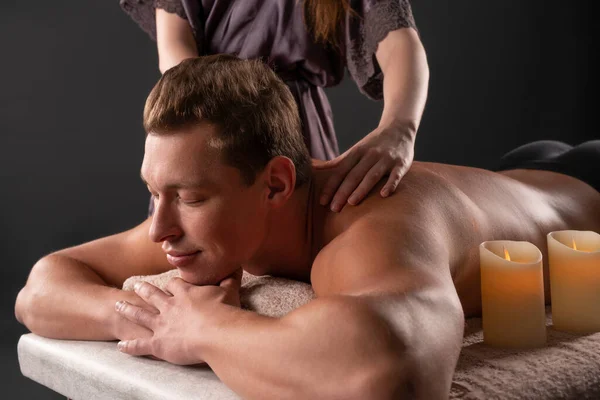Kadın erkek müşterinin sırtına masaj yapıyor. — Stok fotoğraf