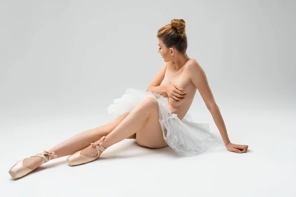 Topless young ballet dancer cover breast in pointe shoes an tutu — Stock Photo, Image