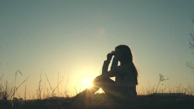 Çim sahada oturan bir genç kız silüeti