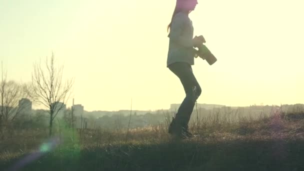Молода дівчина-фотограф ходить по полю — стокове відео