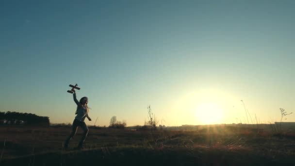 Σιλουέτα του χαρούμενο κορίτσι τρέχει με μικρό παιχνίδι αεροπλάνο — Αρχείο Βίντεο