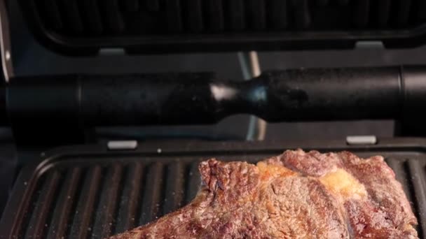 Сочный кусок говяжьего стейка на гриле, приправленный специями — стоковое видео