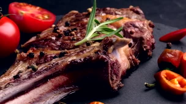 Gegrilltes Rindersteak auf Knochen mit Tomaten — Stockvideo
