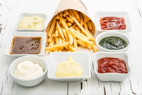 Patatine fritte con salse su sfondo bianco, vista dall'alto — Foto Stock