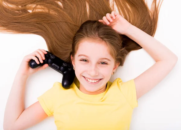 Mädchen dehnt sich mit Joystick in der Hand auf dem Boden — Stockfoto