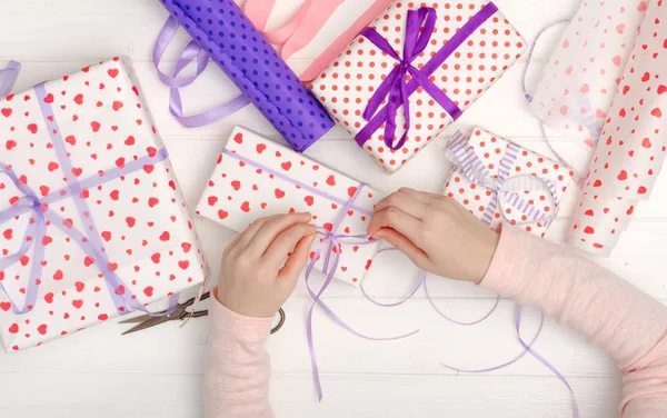 Meisje gebonden lint op het geschenk — Stockfoto