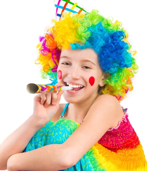 Menina alegre em peruca de palhaço encaracolado e festa chifre soprador Imagem De Stock