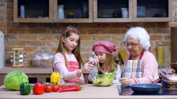 Zusters helpen oma te bereiden salade — Stockvideo