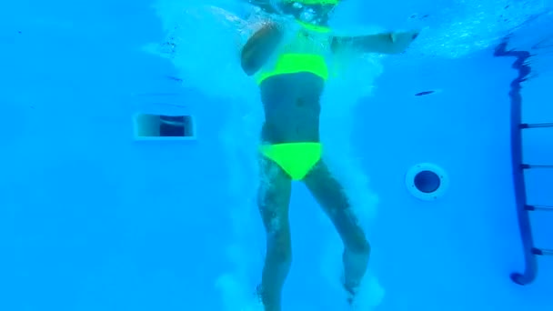 Remek lány medencében víz alá, és mutató — Stock videók