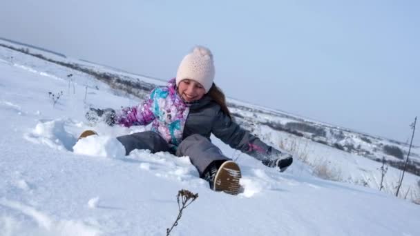 Liten flicka sitter i snön och ha roligt — Stockvideo