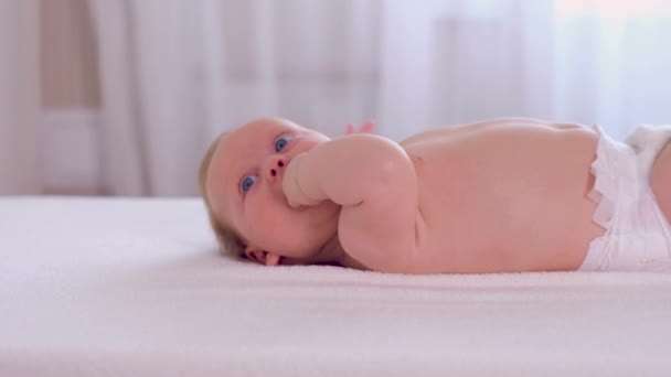 Lindo bebé se encuentra en la cama — Vídeo de stock