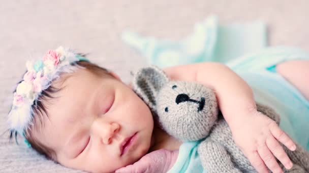Bonito bebê recém-nascido jaz na cama com brinquedo de pelúcia favorito — Vídeo de Stock