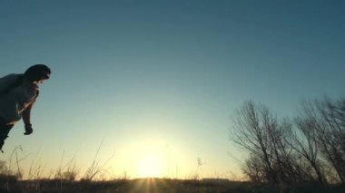 Sırt çantası çim Sahası arasında olan kadın silüeti