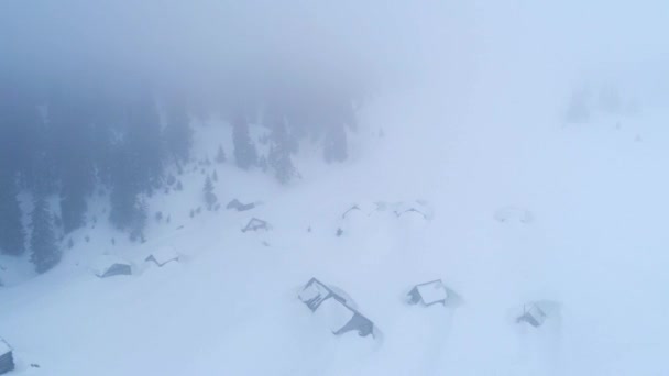 Вид зверху на засніжені хатини в горах — стокове відео