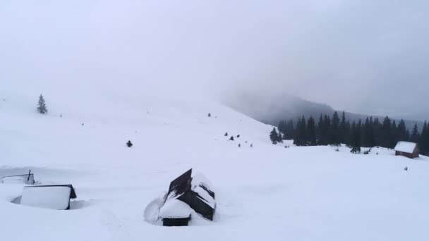 Blick von oben auf verschneite Hütten in den Bergen — Stockvideo