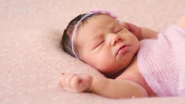 Rozkošné novorozené miminko růžové deky leží na posteli — Stock video