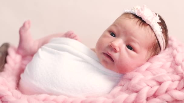 Adorable recién nacido se encuentra en la cama de mimbre rosa — Vídeos de Stock