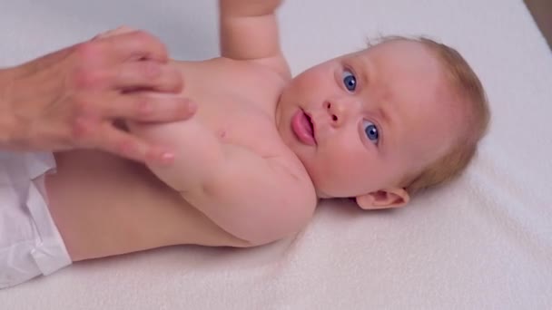 Charmante lachende baby ligt op het bed — Stockvideo