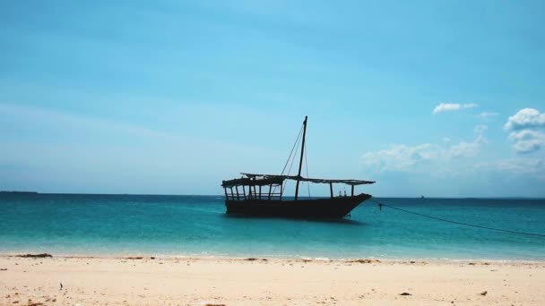 Um barco ancorado perto da costa de areia — Vídeo de Stock