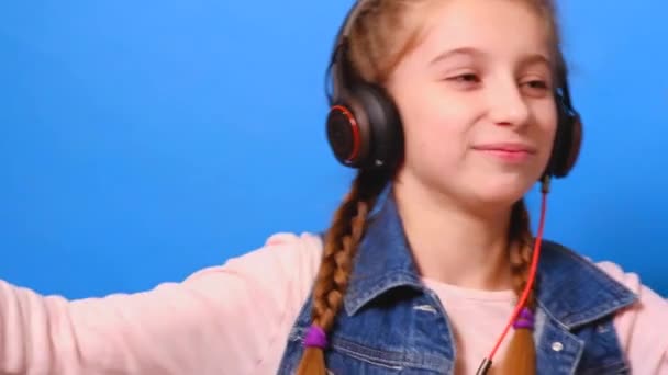 Una niña en auriculares, bailando y disfrutando de la música — Vídeo de stock