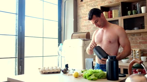 Homem cozinha um cocktail de proteína na cozinha — Vídeo de Stock