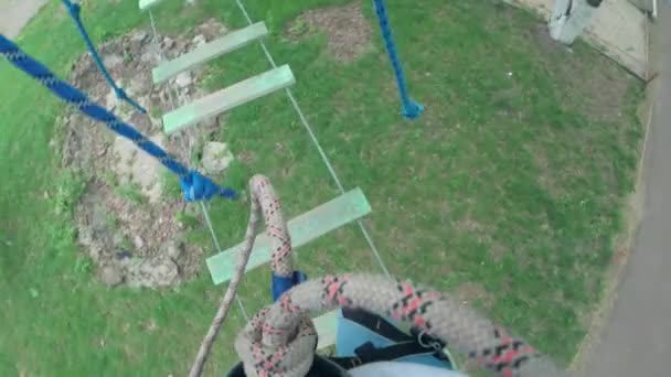 Girl in safety equipment in rope park — Stock Video