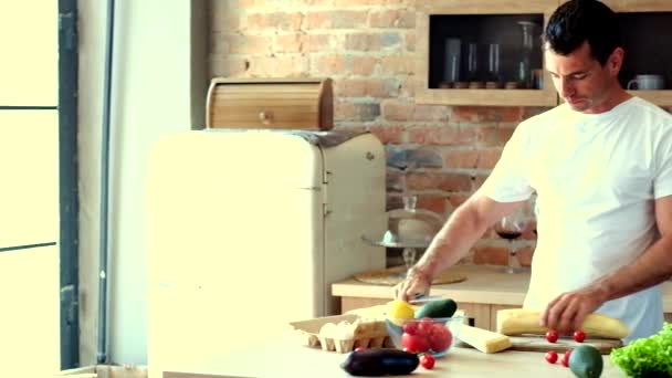 Mann in der Küche schneidet Baguette — Stockvideo
