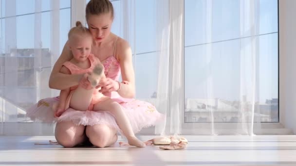 Bonita bailarina enseña a su pequeña hija a atar zapatos de ballet puntiagudos — Vídeos de Stock