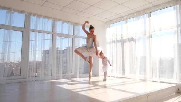 Jonge charmante ballerina leert haar dochtertje dansen in studio — Stockvideo