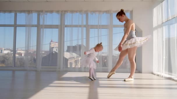 Unga vackra ballerina lär sin lilla dotter dansar i studio — Stockvideo