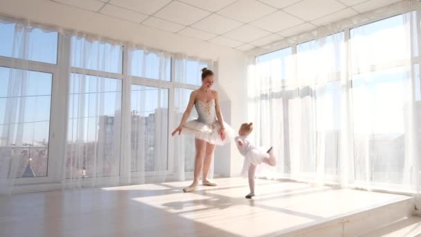 Joven bailarina elegante enseña a su hija a bailar en el estudio — Vídeos de Stock