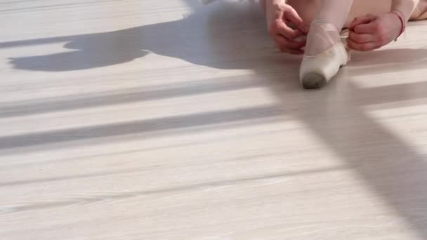 Bailarina em tutu sentado no chão e amarrando sapatos pontiagudos — Vídeo de Stock