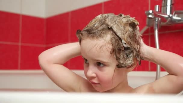 Preciosa niña se lava el pelo con champú — Vídeos de Stock