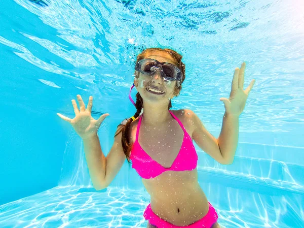 Sorrindo menina nadando debaixo d 'água na piscina — Fotografia de Stock