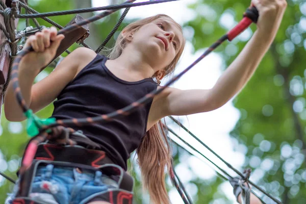 Chica de senderismo en el parque de cuerdas en equipo de seguridad — Foto de Stock
