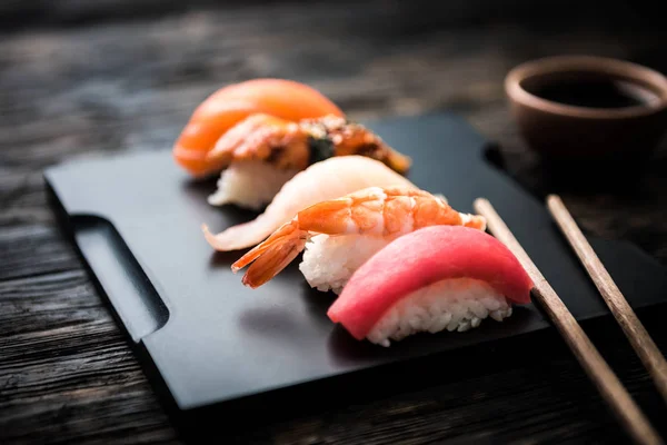 Gros plan de sashimi sushi serti de baguettes et de soja — Photo