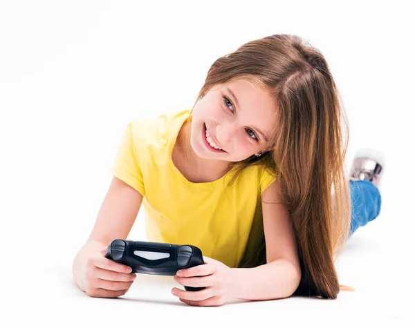 Chica tendida en el suelo, jugando en la consola — Foto de Stock